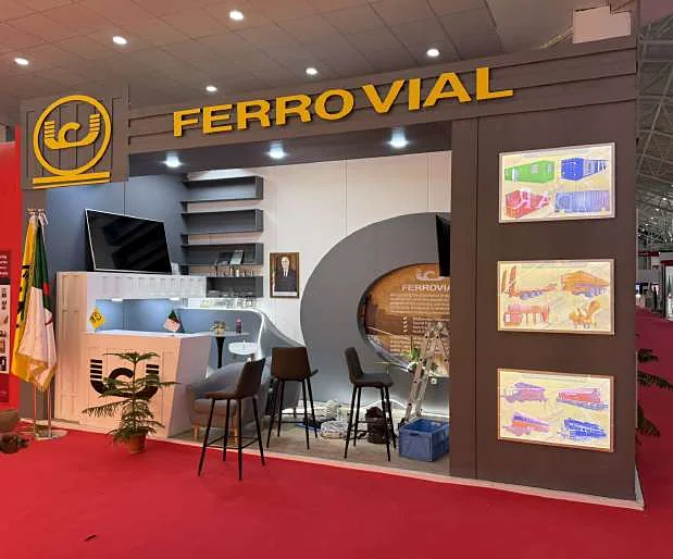 Stand Ferrovial : cloison courbe, enseigne lumineuse et vitrines produits