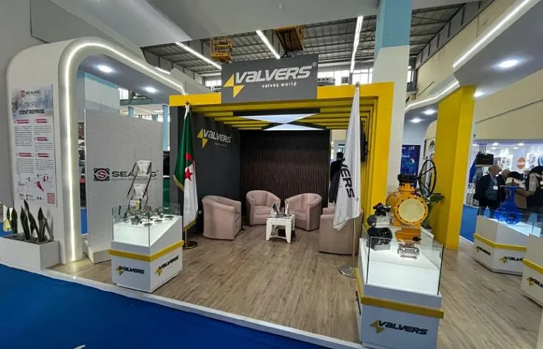 Stand Valvers : portique jaune et noir, salon d’accueil et vitrines produits éclairées